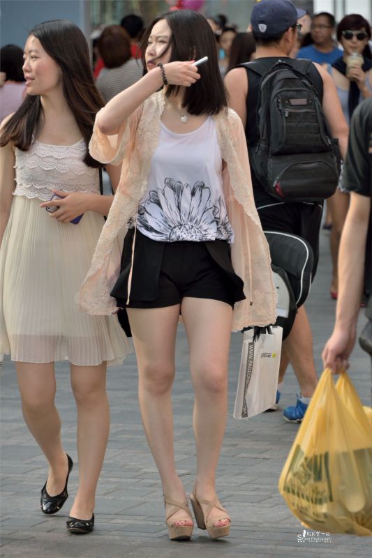 街拍夏日短发热裤美女玩手机